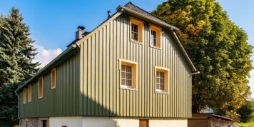 Fichte Deckleistenverschalung mit Hinterlüftung und Holzfaserdämmung – nachhaltig, ästhetisch und fachgerecht umgesetzt von Holzwelten Schlosser GmbH Grün gestrichene Fichtenholzverschalung an einem Bauernhaus in Oelsnitz, ausgeführt als senkrechte Deckleistenverschalung mit Hinterlüftung und Holzfaserdämmung durch die Tischlerei Holzwelten Schlosser GmbH.