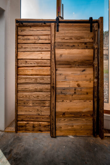 Rustikale Altholz-Schiebetür – maßgefertigt von der Tischlerei Holzwelten Schlosser Rustikale Schiebetür aus Altholz mit schwarzer Laufschiene, gefertigt von der Tischlerei Holzwelten Schlosser in Oelsnitz